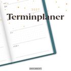 "2027 Terminplaner" steht in großen Buchstaben. Offener Terminkalender mit Datumseinträgen und blauem Einband.