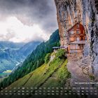 Berggasthaus Äscher - Wildkirchli. Eine Berghütte an einer steilen Felswand, mit Blick auf ein grünes Tal und bewaldete Berge.