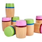 Holzklötze, bemalt in Grün, Pink und Blau, stehen übereinander.