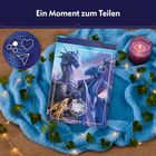 "Ein Moment zum Teilen" steht oben. Box mit Drachenabbildung auf blauem Tuch, umgeben von Lichtern, Efeu und Kerze.
