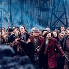 Eine Gruppe von Menschen, gekleidet in historischer Kleidung, bewegt sich entschlossen und energisch nach vorne.