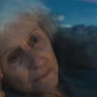 Eine ältere Frau und eine jüngere Frau sitzen nebeneinander, beide sehen nachdenklich aus.