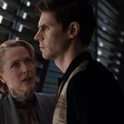 Eine Frau und ein Mann stehen in einem dunklen Raum mit Lamellen. Sie blickt ihn ernst an; er schaut nach vorne.