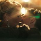 Ein Paar küsst sich leidenschaftlich in einer verschwommenen, warm beleuchteten Umgebung.