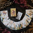 „Summer Serenade Lenormand“ steht auf zwei Schachteln. Darum liegen bunte Karten in einem Bogen.