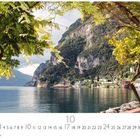 "Riva del Garda" steht links oben, darunter ein Kalender für Oktober. Uferlandschaft mit Bäumen im Vordergrund.