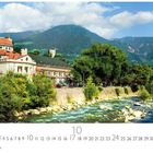 Text: "Meran, 10". Gebäude mit rotem Dach, Fluss im Vordergrund, Berge im Hintergrund, Bäume säumen das Ufer.