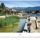 "Baveno", Monatskalender mit Datum und Casares Edition. Es zeigt eine malerische Uferpromenade mit Pflanzen und Bergen.