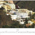Calera im Valle Gran Rey. Kalenderseite mit Datum für Oktober. Bunte Häuser an einem steilen Hang, umgeben von Palmen.