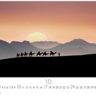 Kalenderblätter mit Zahlen 1 bis 31, darunter "Casares Edition". Silhouette von Kamelkarawane in Wüstenlandschaft bei Sonnenuntergang.