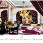 Innenansicht Grand Hotel Cabourg. Eleganter Raum mit Kronleuchter, Säulen, violetten Vorhängen und einem dekorativen Teppich.
