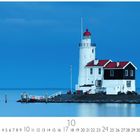 Paard van Marken, Niederlande. Ein Leuchtturm auf einer kleinen Landzunge, umgeben von ruhigem Wasser und blauem Himmel.