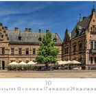 "Burg" steht unten links. Historische Gebäude mit Ziegeldächern umgeben einen Innenhof, Baum und Sonnenschirme über Tischen.