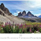 "Italien, Südtirol, Drei Zinnen. CASA RES EDITION. Berglandschaft mit felsigen Gipfeln unter blauem Himmel und lilafarbenen Blumen."