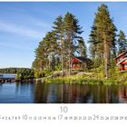 Häuser am See. Kalender für Oktober. Zwei rote Holzhäuser stehen in einem Nadelwald am Ufer eines ruhigen Sees.
