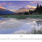 10. Landschaft mit Bergen im Hintergrund, See im Vordergrund, umgeben von Bäumen und Gräsern unter rosafarbenem Himmel.
