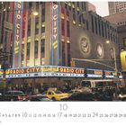 Text „Radio City Music Hall“ leuchtet in großen Buchstaben. Taxi in belebter Straßenansicht vor dem Eingang.