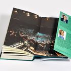 Ein offenes Buch, rechts ein grüner Einleger mit Biografien und Fotos von Howard Viesel und Sabine Eichhorst. Links ein Konzert.