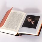 Eine aufgeschlagene Buchseite mit viel Text. Rechts ein Foto einer Person mit Sonnenbrille und dunkler Jacke.