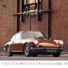 Kalenderseite für Oktober zeigt ein klassisches Auto vor einer Ziegelwand.