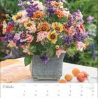 Kalenderseite Oktober. Bunte Blumendeko in einer Vase, umgeben von Aprikosen. Datum: 2021. Feiertage: 3., 31.