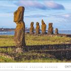 Texte: "OKTOBER", Kalendertage darunter. 
Große Steinskulpturen am Meer, grüne Wiese, blauer Himmel mit Wolken.
