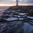 Kalenderblatt mit dem Text "10 2021". Ein Leuchtturm steht auf felsigem Ufer vor einem dramatischen Himmel bei Sonnenuntergang.