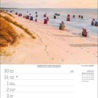 20. Montag bis 26. Sonntag September. Holzweg durch Dünen in grüner Küstenlandschaft bei Sonnenaufgang.