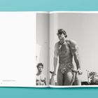Text "Mr. Universe". Mehrere Bodybuilder posieren auf der Bühne im Wettbewerb. Die Szene ist in Schwarz-Weiß gehalten.