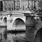Kalenderblatt mit Oktoberdaten. Zitat von Jean Giraudoux: "In Paris..." Pont Neuf über einem Fluss vor historischen Gebäuden.