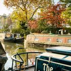 Der Text "The Jenster", Kalenderdaten für Oktober; Szene mit Fluss, Hausbooten, herbstfarbene Bäume, blauer Himmel.