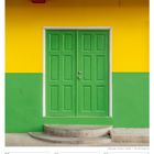 Text: "FEBRUAR 2027", "06. Woche", "08 Mo", "09 Di", "10 Mi", "11 Do", "12 Fr", "13 Sa", "14 So". Grüne Tür auf gelbem Hintergrund.