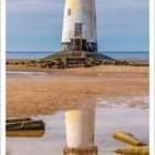 Oktober-Kalenderblatt mit einem Leuchtturm am Strand, dessen Reflexion im Wasser sichtbar ist.
