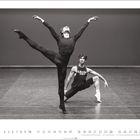 „Stuttgarter Ballett“ steht auf einem Shirt. Zwei Tänzer in einer Ballettpose auf einer Bühne. Calm und anmutig, schwarz-weiße Szene.