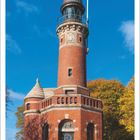 Oktober 2027, Leuchtturm Holtenau, Kiel, Deutschland. Ein roter Backsteinleuchtturm vor blauem Himmel.