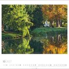 10, 2027. Park Sanssouci, Potsdam. Eine grüne Landschaft mit Bäumen und einem Teich, der das Herbstlaub spiegelt.