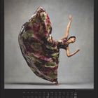 Oktoberkalender; eine Tänzerin in einem fließenden, gemusterten Kleid in dynamischer Pose.