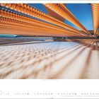 Text: "STEINWAY GRAND PIANO - Foto © Charles Brooks." Rautenförmige Schatten und goldene Saiten bilden ein Muster gegen blauen Himmel.