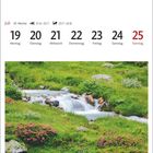 Kalenderseite mit Juli-Daten. Im unteren Bereich ein Bild eines Bergbachs, umgeben von grüner Vegetation und Blumen.