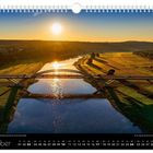 Oktober. Sonnenaufgang über Brücke, Fluss und Felder im Hintergrund, mit Kalenderdaten unten.