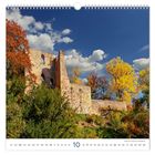 Kalender zeigt Oktober, Burgruine, Bäume in Herbstfarben vor blauem Himmel, Burgmauer aus Stein, Wolken am Himmel.