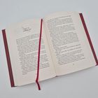 Ein geöffnetes Buch mit rotem Einband. Links oben steht: "AKT II: SZENE XII". Eine rote Lesebändchen liegt diagonal.