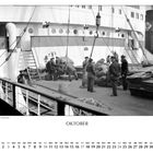 „Sackgut wird gewogen“ und „OKTOBER“. Männer hantieren mit Säcken auf einem Schiff. Kalender mit Oktober-Daten.