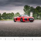 Text: "Audi R8 Spyder V10 RWD", "OKTOBER". Ein rotes Cabrio steht auf einer asphaltierten Fläche, im Hintergrund Bäume.
