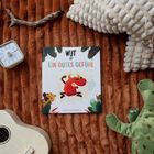 „WUT ist EIN GUTES GEFÜHL“ steht auf einem Kinderbuch. Darum: Ukulele, Eieruhr, Stoffdino, kuschelige Decke.