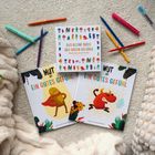 Drei bunte Kinderbücher über Gefühle, umgeben von bunten Stiften, weichen Kissen und einer Häkel-Figur.