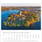 10 | 2027 Schleswig-Holstein Land zwischen den Meeren. Kalender mit Luftbild einer Insel und Stadt am Wasser, herbstliche Bäume.