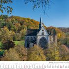 Altenberg - Blick auf den Altenberger Dom von Westen. Eine gotische Kirche umgeben von buntem Herbstlaub und Hügeln. Kalenderblatt für Oktober 2027.