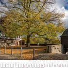Kalender für Oktober 2027 mit Schlossanlage, Fachwerkhaus, herbstlichen Baum und Kopfsteinpflaster.