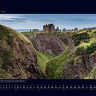 06 Juni. Ruinen einer alten Burg auf steilen Klippen, umgeben von grünem Gras und bewölkter Himmel im Hintergrund.